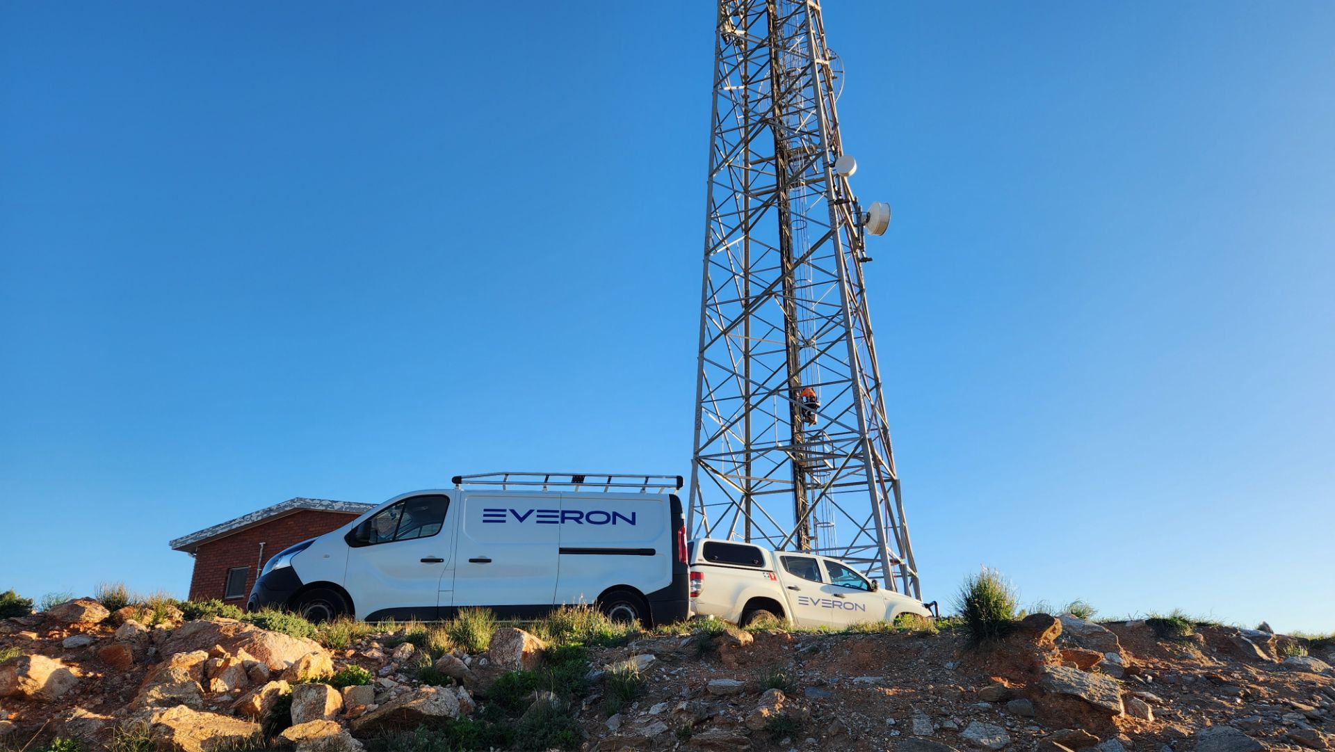 Telecom tower with an Everon van parked in front